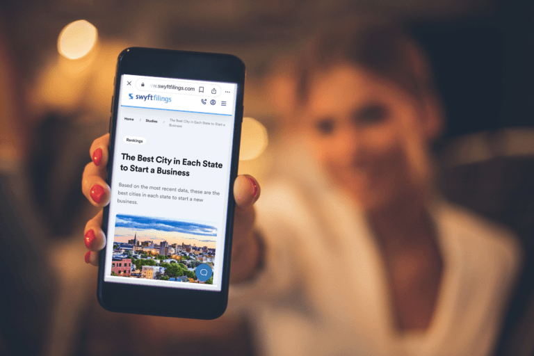 woman holding a phone displaying swyft filings website